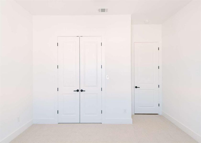 Unfurnished bedroom with a closet and light colored carpet