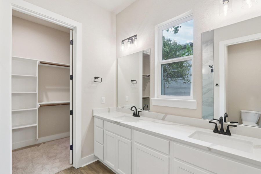 Primary ensuite bath featuring modern oversized walk-in shower with floor-to-ceiling tile and dual vanity with quartz countertops Primary ensuite bath featuring modern oversized walk-in shower with floor-to-ceiling tile and dual vanity with quartz countertops