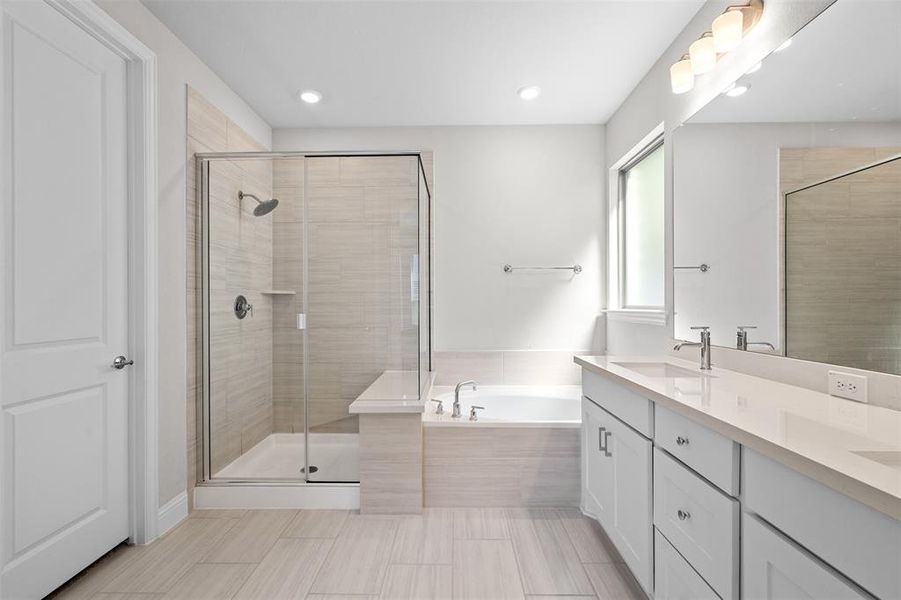 Bathroom featuring vanity and separate shower and tub