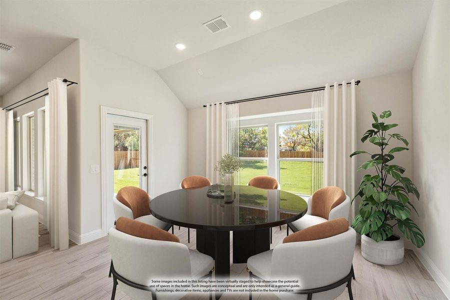 Dining area with round dark table, six chairs, vaulted ceiling, and large windows overlooking backyard