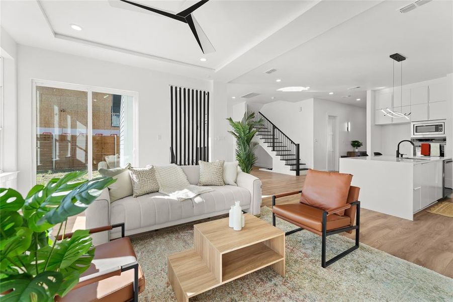 Living room featuring light wood-style flooring, recessed lighting, and a ceiling fan