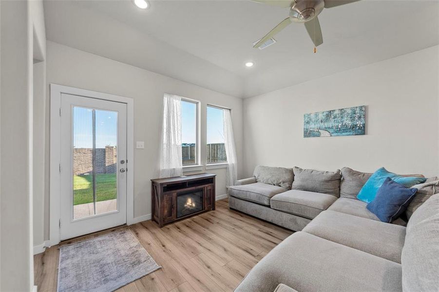Living room with light wood-type flooring, recessed lighting, and a ceiling fan Living room with light wood-type flooring, recessed lighting, and a ceiling fan