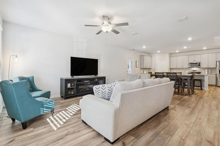 Living room featuring light wood-type flooring, recessed lighting, and a ceiling fan