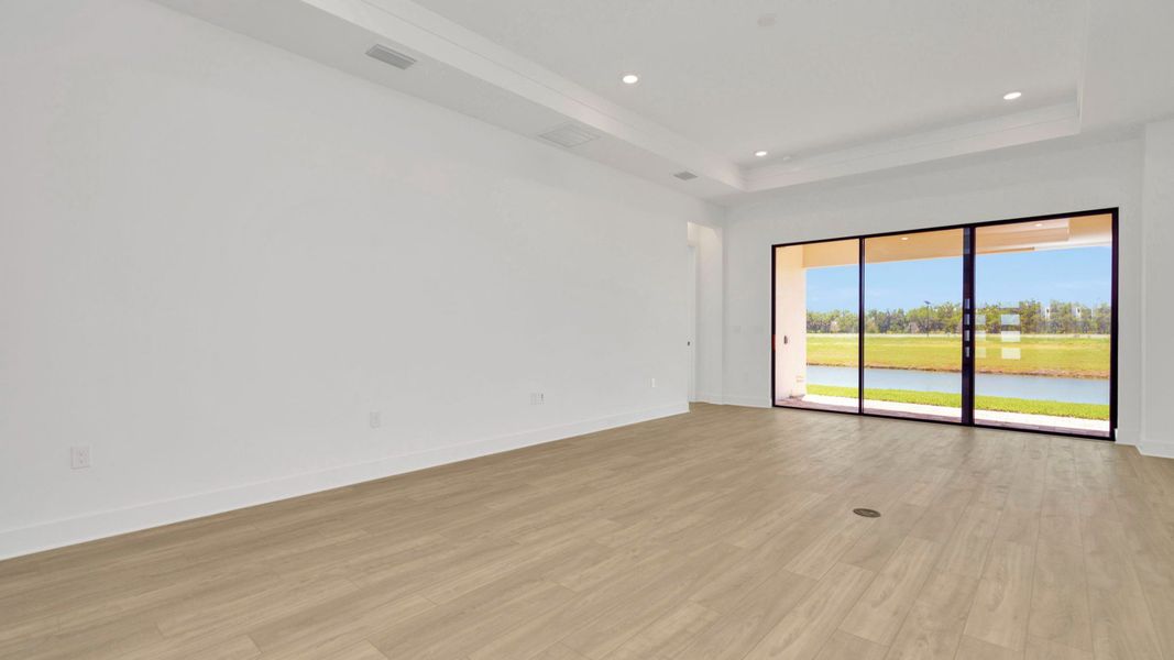 The Living Room of a DRB Homes Grand Hawk which is offered as a home plan at Serengeti in Spring Hill, FL.