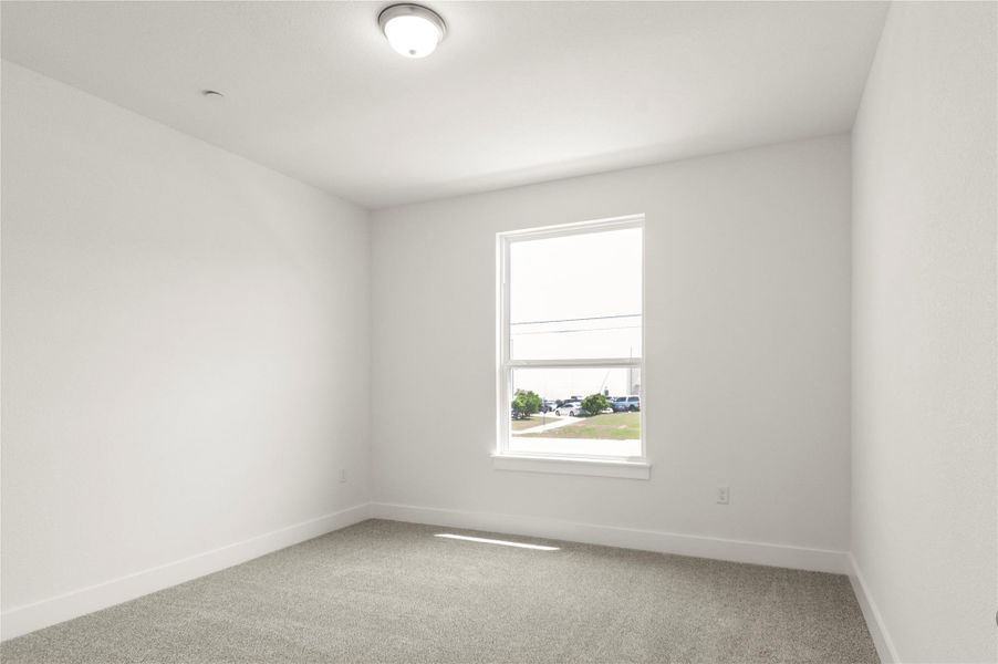 Carpeted spare room with baseboards