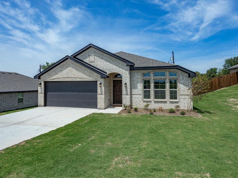Single-story residence featuring a light-colored brick exterior with dark trim accents Single-story residence featuring a light-colored brick exterior with dark trim accents
