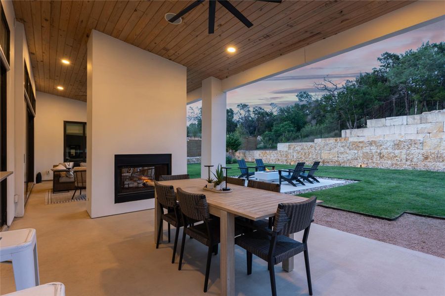 Spacious covered patio with wood-panel ceiling, recessed lighting, and an outdoor fireplace Spacious covered patio with wood-panel ceiling, recessed lighting, and an outdoor fireplace