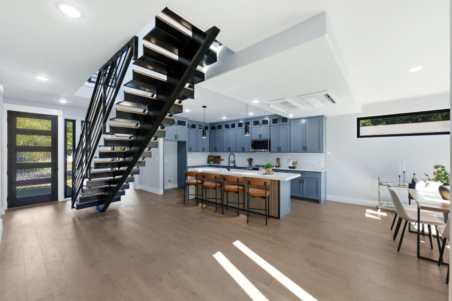 Kitchen featuring plenty of natural light, light countertops, a breakfast bar area, light wood-type flooring, and recessed lighting Kitchen featuring plenty of natural light, light countertops, a breakfast bar area, light wood-type flooring, and recessed lighting