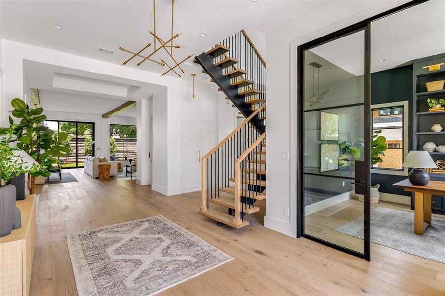 Entrance foyer with light hardwood / wood-style floors and an inviting chandelier