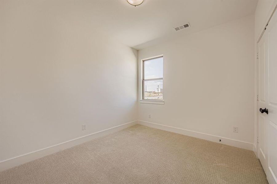 Carpeted spare room featuring baseboards Carpeted spare room featuring baseboards