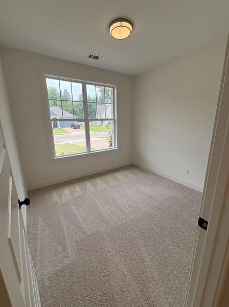Neutral interior space featuring light-toned carpeting and white walls