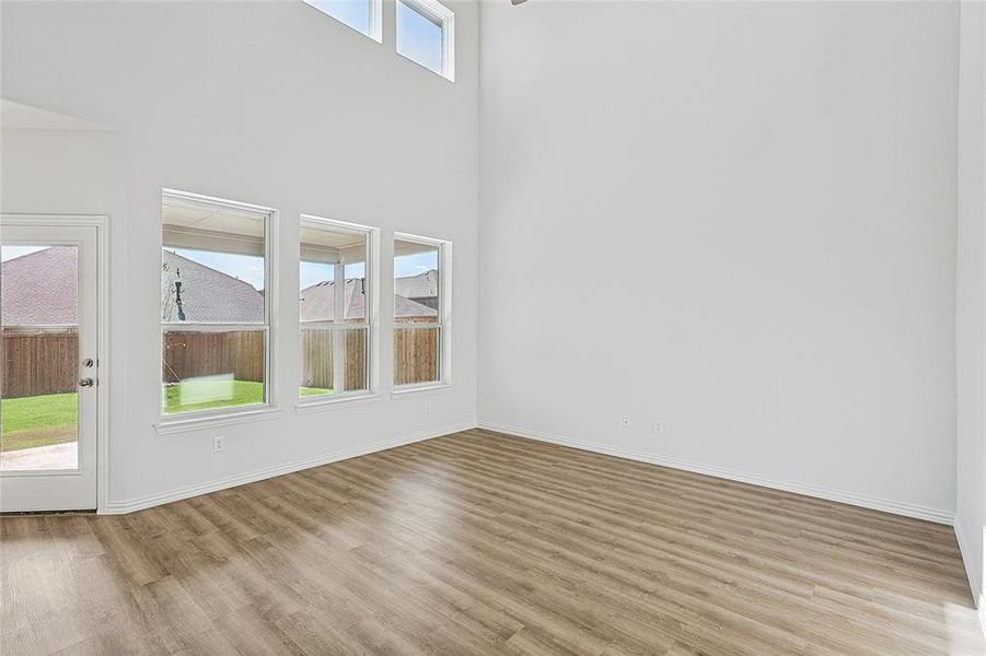 Unfurnished living room with a high ceiling and light hardwood / wood-style floors