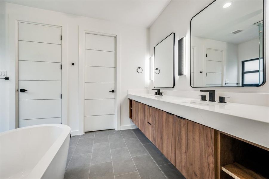 Bathroom featuring a soaking tub, double vanity, and tile patterned floors Bathroom featuring a soaking tub, double vanity, and tile patterned floors