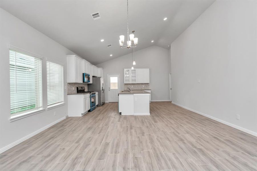 The open-concept kitchen and dining area offer a spacious and airy environment, perfect for family gatherings and entertaining. The kitchen features modern appliances, ample counter space, and stylish cabinetry, all highlighted by the natural light streaming through large windows. This space is designed for those who love to cook and entertain in style. **This image is from another Saratoga Home - Wren floorplan.**