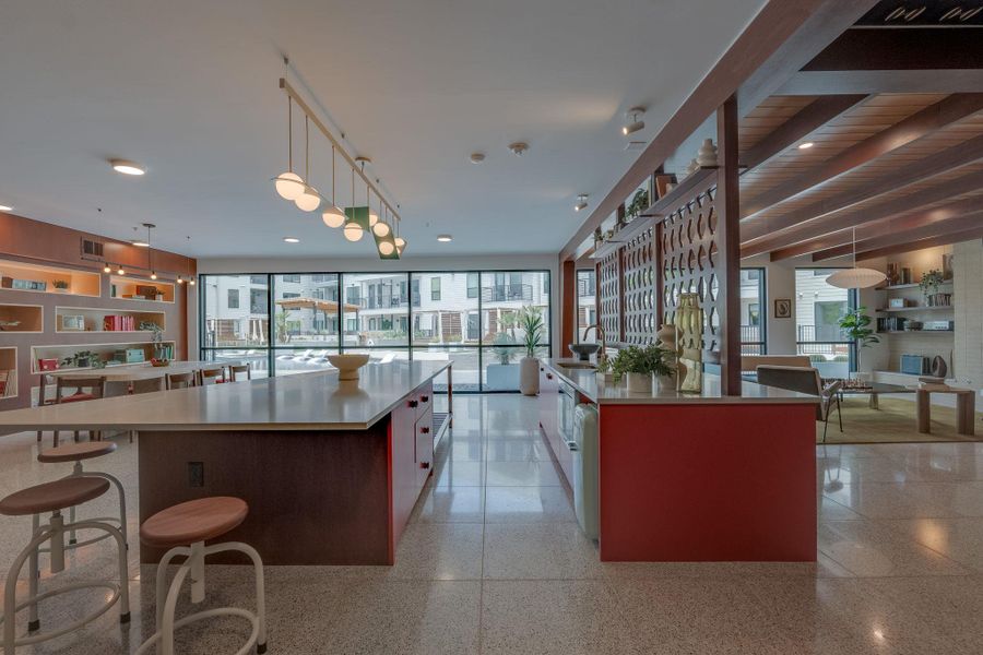 The interior features a spacious open-concept room with light-colored flooring and large windows