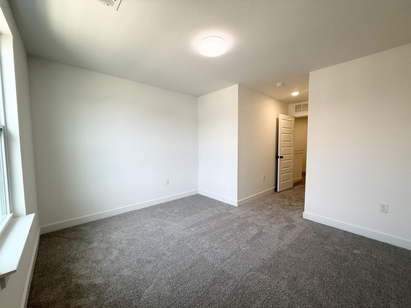 Unfurnished room featuring dark carpet and baseboards