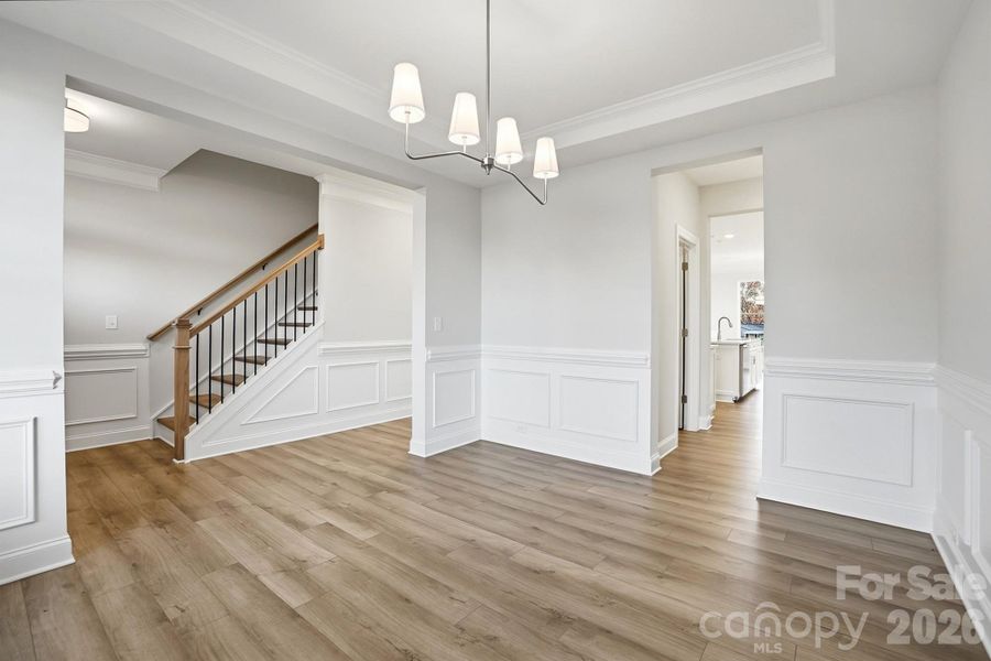 Dining room with tray ceiling and wainscoting
