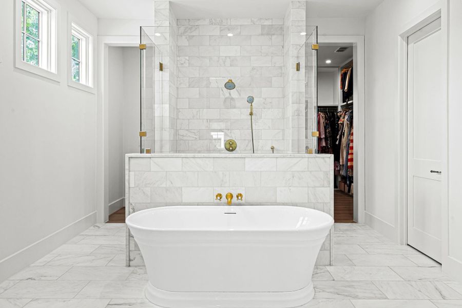 Designed w/ both luxury & functionality in mind, the oversized shower situated behind the soaking tub features a frameless glass enclosure, marble surround & herringbone-patterned marble flooring. Dual showerheads and entrances & built-in soap niches enhance the space. Designed w/ both luxury & functionality in mind, the oversized shower situated behind the soaking tub features a frameless glass enclosure, marble surround & herringbone-patterned marble flooring. Dual showerheads and entrances & built-in soap niches enhance the space.