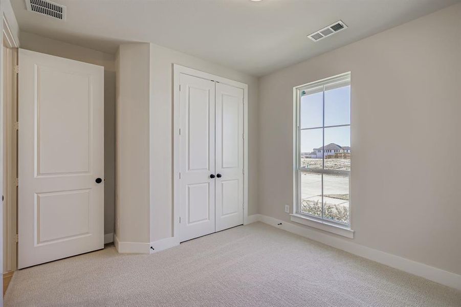Unfurnished bedroom featuring light colored carpet and a closet