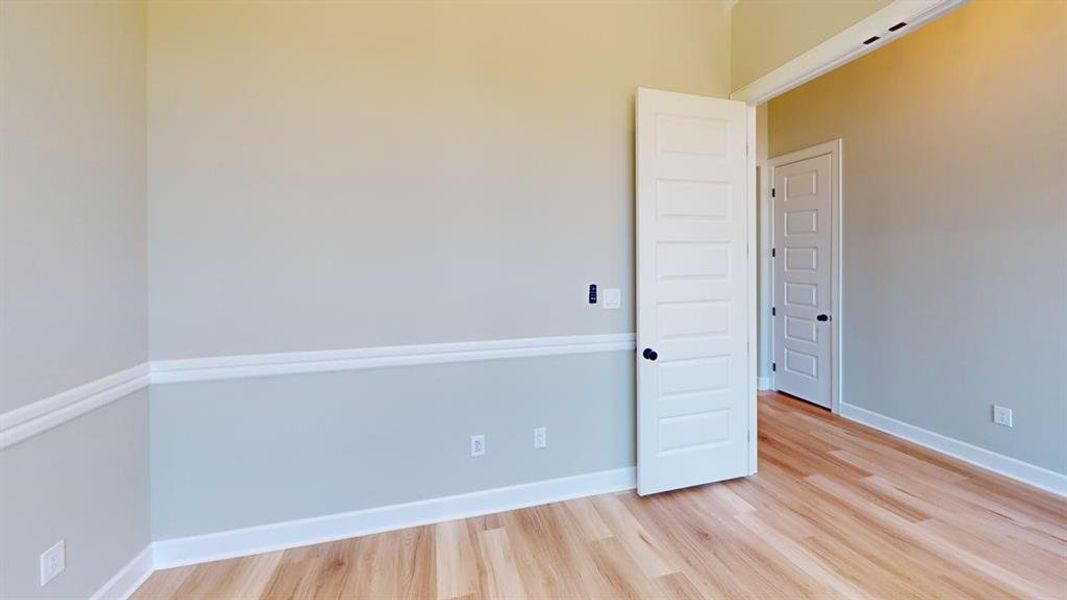 Unfurnished room featuring light wood finished floors and baseboards