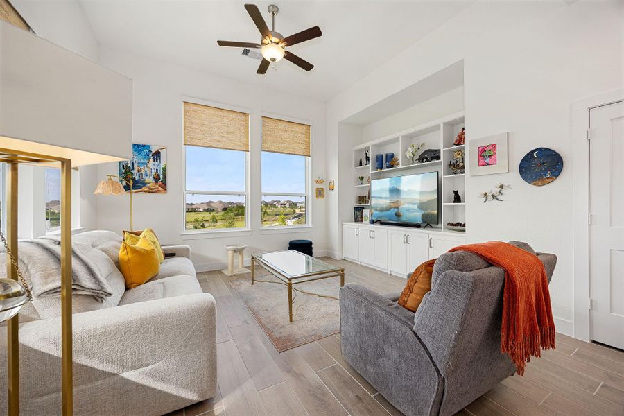 Living room overlooking the beautiful walking trails, greenspace and pond behind the home.