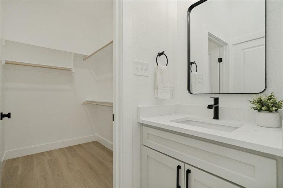Bathroom vanity featuring a rectangular undermount sink, white countertop, and matte black faucet Bathroom vanity featuring a rectangular undermount sink, white countertop, and matte black faucet