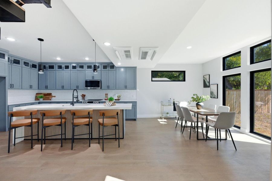 Kitchen featuring a breakfast bar area, plenty of natural light, tasteful backsplash, recessed lighting, and light wood finished floors Kitchen featuring a breakfast bar area, plenty of natural light, tasteful backsplash, recessed lighting, and light wood finished floors
