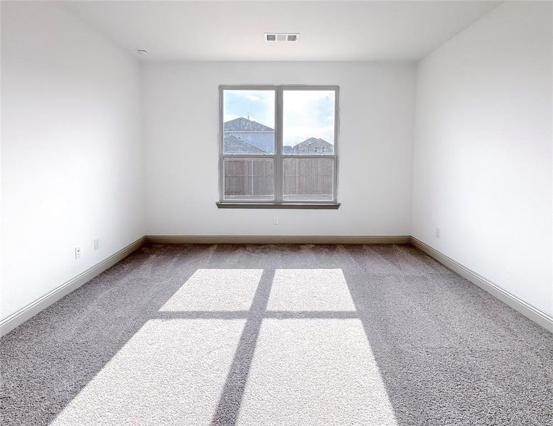 Unfurnished room featuring visible vents, carpet, and baseboards