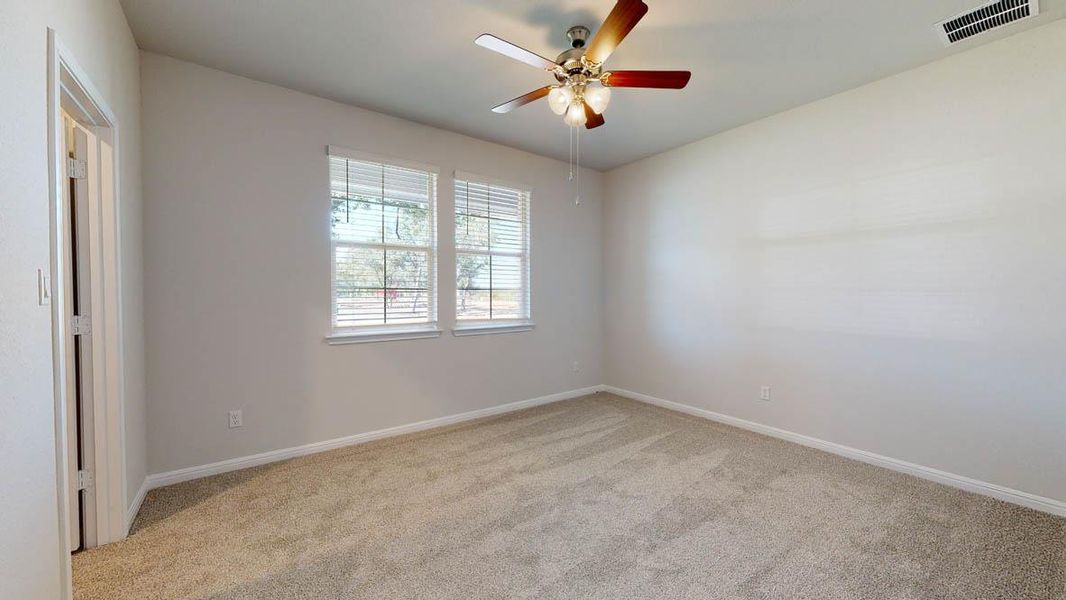 Spare room featuring light colored carpet and a ceiling fan