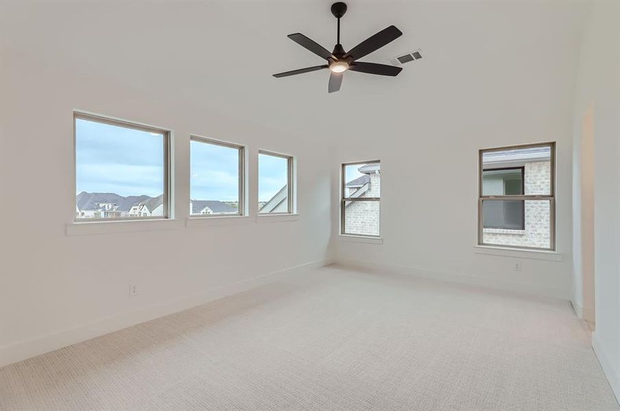 Carpeted spare room with ceiling fan