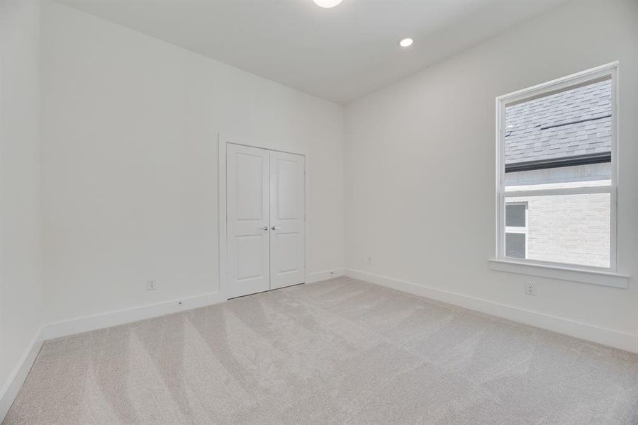 Unfurnished bedroom featuring light colored carpet, recessed lighting, and a closet