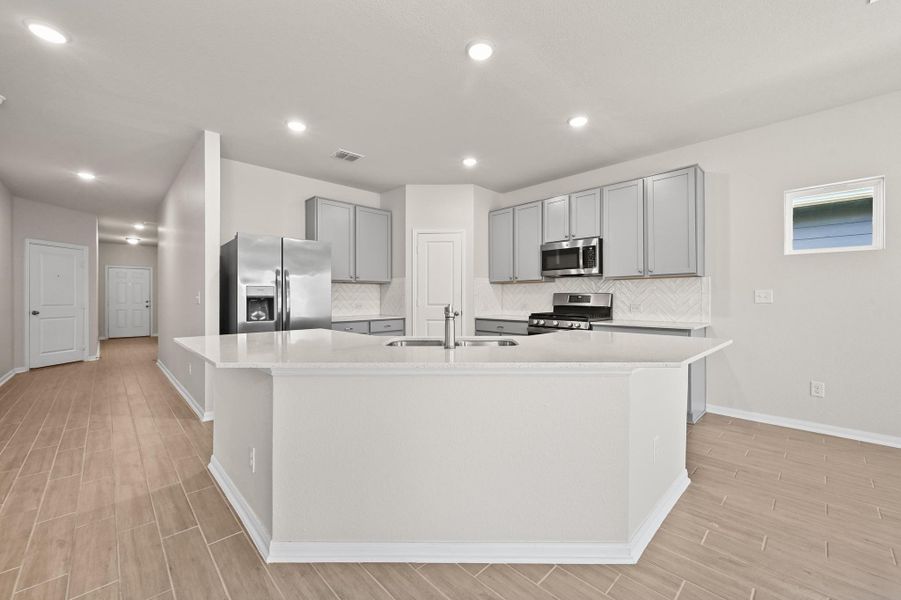 Open kitchen with light cabinets and island.