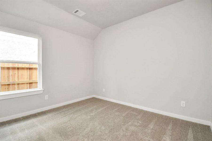 Secondary bedroom features plush carpeting, large windows that let in plenty of natural light, bright paint, and spacious closets.