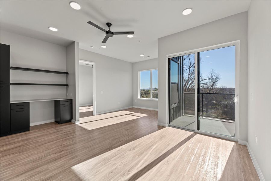 Unfurnished bedroom featuring ceiling fan, access to exterior, and light wood-type flooring