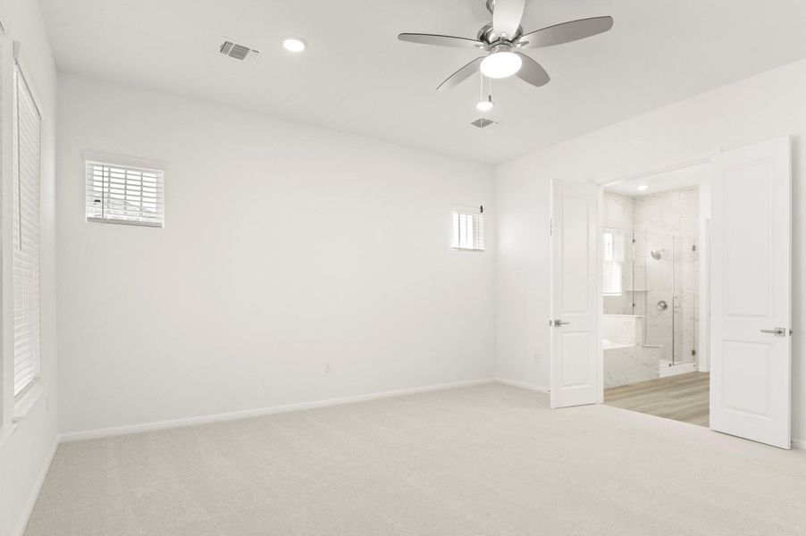 Unfurnished bedroom with light colored carpet, ceiling fan, multiple windows, and recessed lighting