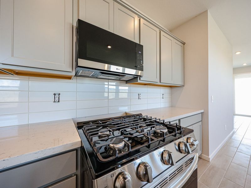 A kitchen with white cabinets.