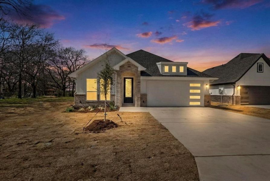 View of front of property featuring driveway, brick siding, and a garage View of front of property featuring driveway, brick siding, and a garage