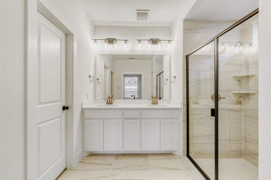 Bathroom with double vanity, light marble finish flooring, and a shower stall Bathroom with double vanity, light marble finish flooring, and a shower stall
