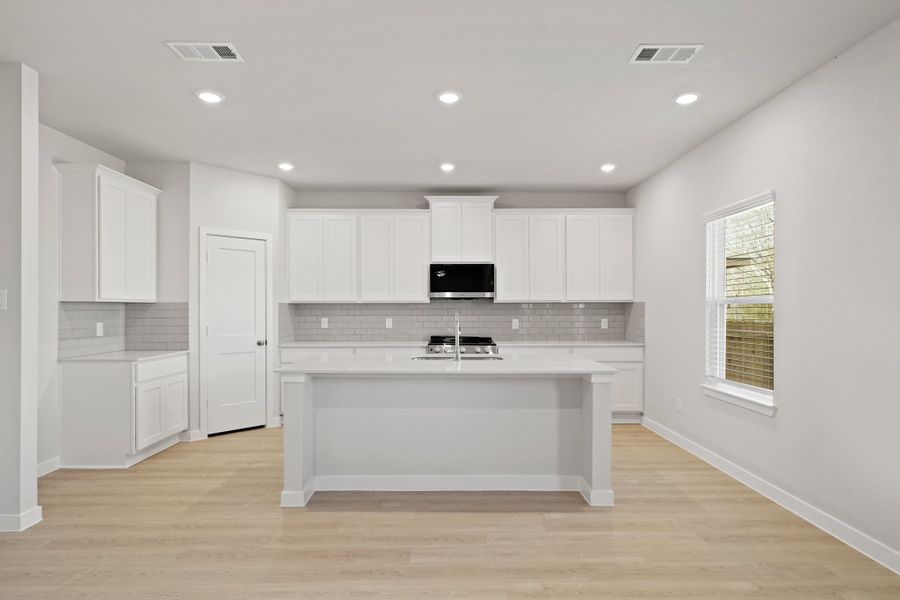 A kitchen with white cabinets.