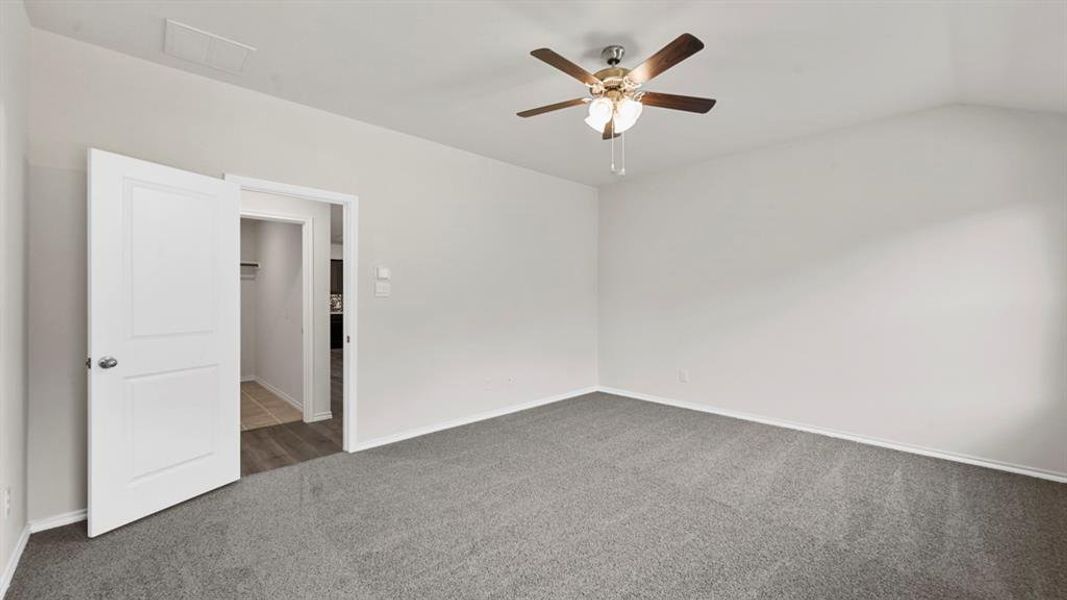 Spacious room featuring neutral grey carpeting, light-toned walls, and a ceiling fan with integrated lighting Spacious room featuring neutral grey carpeting, light-toned walls, and a ceiling fan with integrated lighting