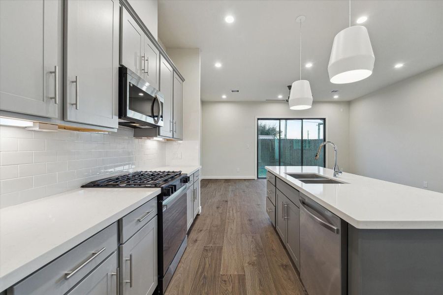Thoughtfully designed cabinetry, stainless appliances, and quartz countertops create a sleek, functional kitchen built for both everyday living and entertaining.