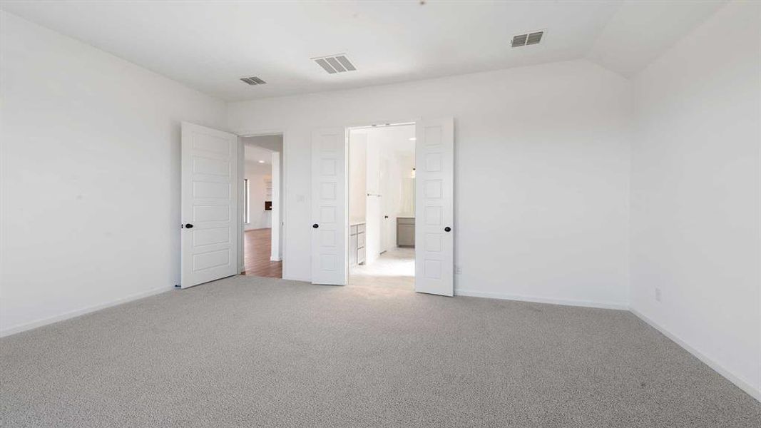 Carpeted spare room with vaulted ceiling