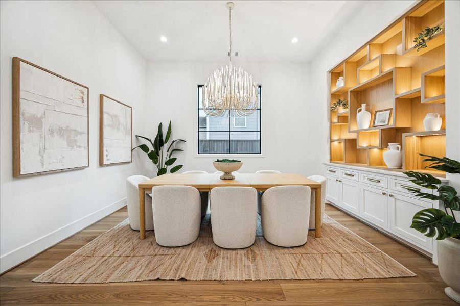 Soft natural light, curated lighting, and warm oak floors create an inviting dining atmosphere. Wide openings reinforce the open flow, supported by 8 ft interior doors and consistent millwork.