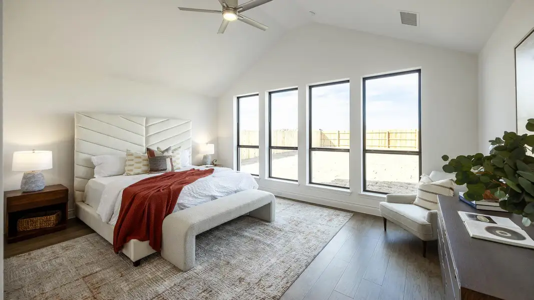 Bedroom featuring lofted ceiling, ceiling fan, wood finished floors, and visible vents