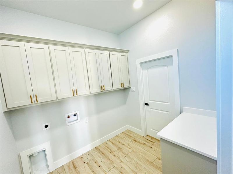 Clothes washing area featuring cabinets, washer hookup, light hardwood / wood-style flooring, and electric dryer hookup