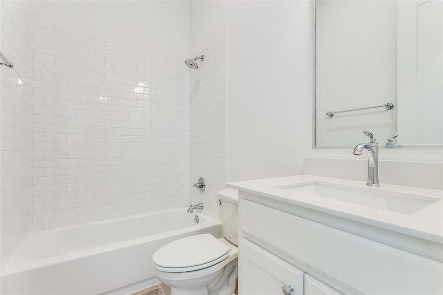 Full bathroom featuring tiled shower / bath, vanity, and toilet