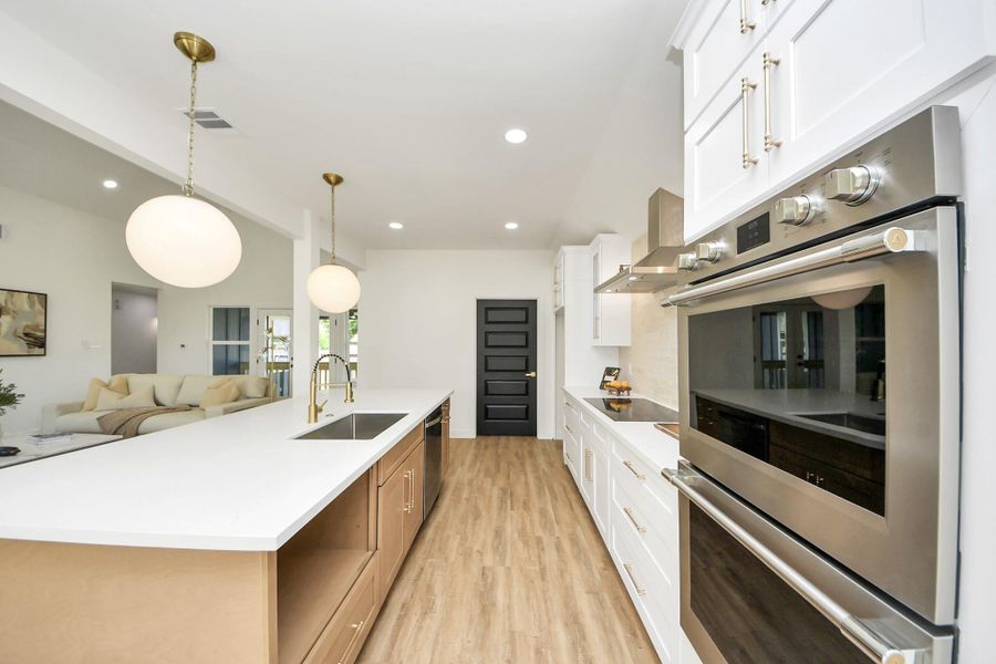 This modern kitchen strikes the perfect balance between style and function. White cabinetry and stainless steel accents feel fresh and refined, while warm wood-like floors and pendant lighting add an inviting touch. The oversized island is more than just a workspace—it’s a natural gathering spot that flows effortlessly into the heart of the home. This modern kitchen strikes the perfect balance between style and function. White cabinetry and stainless steel accents feel fresh and refined, while warm wood-like floors and pendant lighting add an inviting touch. The oversized island is more than just a workspace—it’s a natural gathering spot that flows effortlessly into the heart of the home.