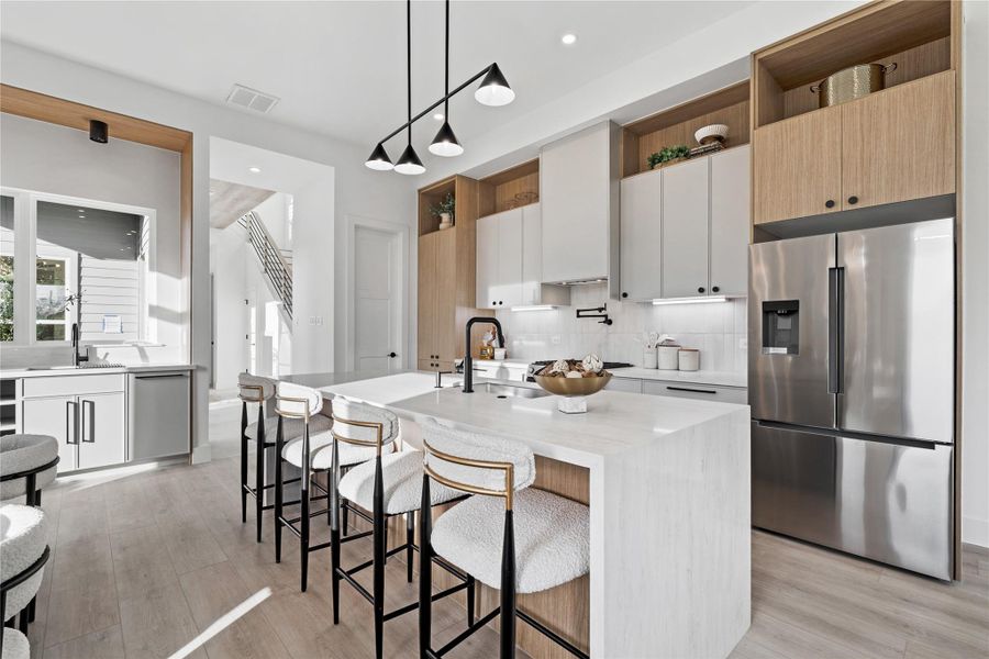From the expansive island to the integrated wet bar, every detail supports connection and convenience. Natural textures and clean lines give the space a polished yet welcoming presence.