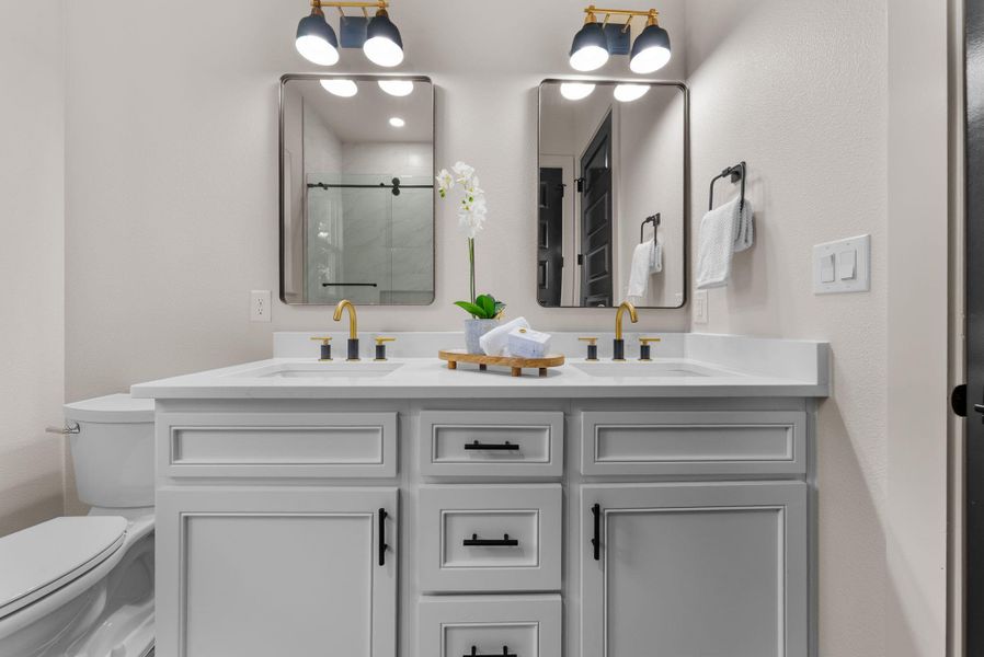 A sleek vanity with dual sinks, mirrors, and modern lighting offers ultimate convenience.