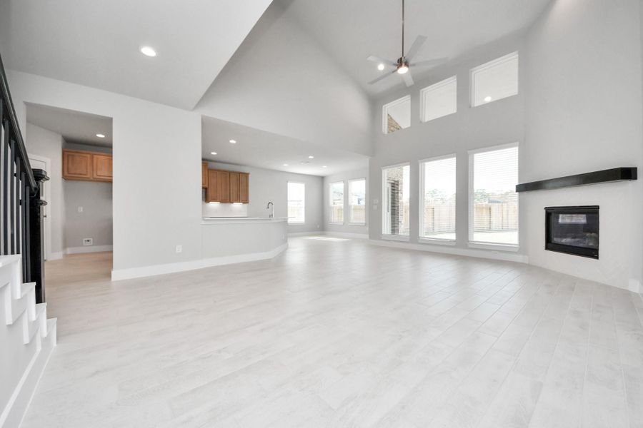 Gather the family and guests together in your lovely living room! Featuring soaring high ceilings, recessed lighting, ceiling fan, custom paint, gorgeous floors, and large windows that provide plenty of natural lighting throughout the day.